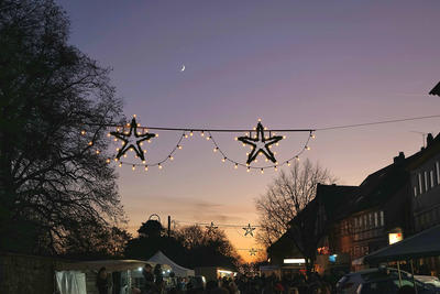 Bild vergrößern: Blick über den Weihnachtsmarkt mit Weihnachtsbeleuchtung